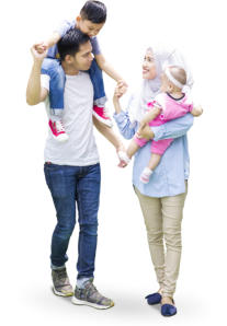 A young family is walking together: the mom carries a baby in her arms as she smiles up at the young boy on his father's shoulders.