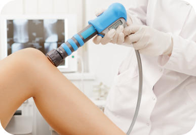 A medical technician uses an ultrasound wand to examine the heel of a young patient. The ultrasound screen image is in the background.