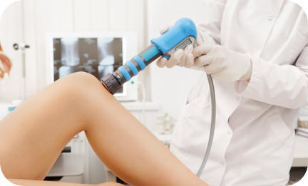 A medical technician uses an ultrasound wand to examine the heel of a young patient. The ultrasound screen image is in the background.