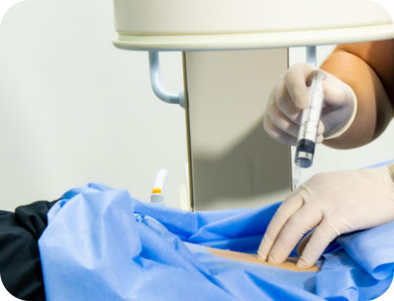 A physician wearing gloves gives an injection into the back of a patient lying face-down on a treatment table.