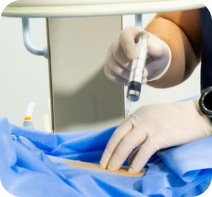 A physician wearing gloves gives an injection into the back of a patient lying face-down on a treatment table.