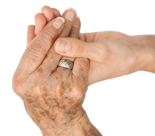 A close-up of an old woman's hand holding a young woman's hand. 