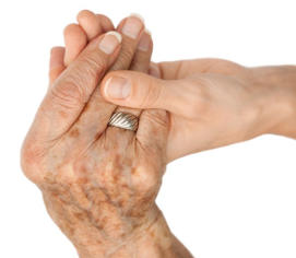 A close-up of an old woman's hand holding a young woman's hand. 