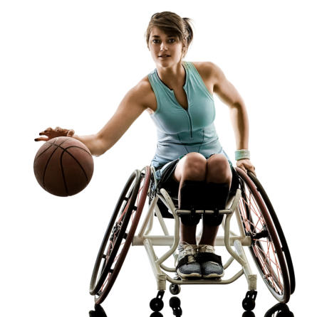 A woman in athletic wear bounces a basketball while sitting in a wheelchair