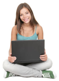 A young woman is sitting on the ground holding a laptop computer, looking at the camera and smiling.